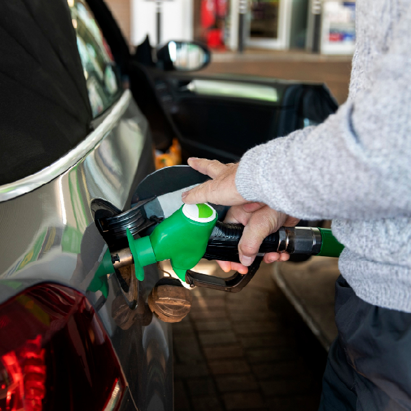 Technician refueling car during emergency fuel delivery service